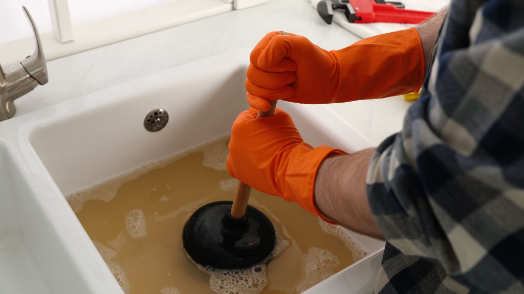 Homeowner unclogging a sink drain