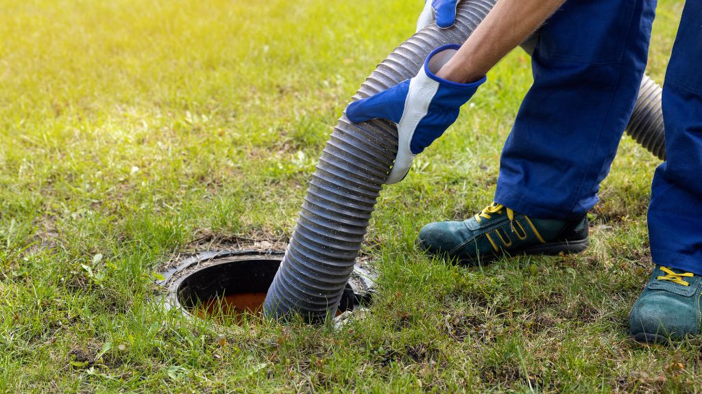 technician pumping septic tank in early fall